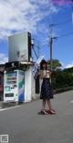 A woman standing in the middle of a street holding an umbrella.